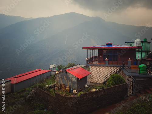 Photography A serene mountain village with red-roofed houses and lush greenery near Madmahes