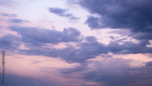 Purple clouds on pink sky at sunset or sunrise, soft twilight colors creating calm atmospheric background