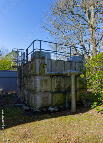 The lower Overspill or Feeder water tank for Stracathro Hospital, with insulated pipework and valves visible on its exterior.