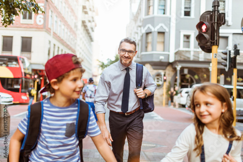Fotografía Father walking with kids to school in city crosswalk