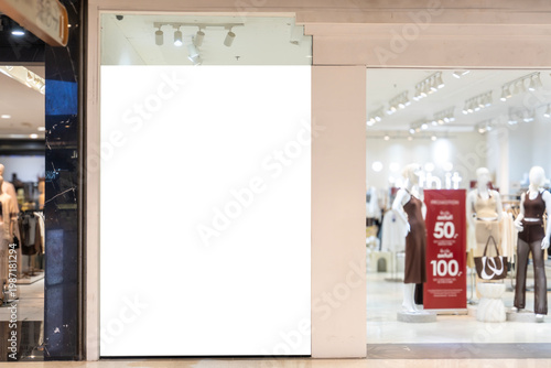 Blank illuminated storefront poster panel mockup at fashion store entrance