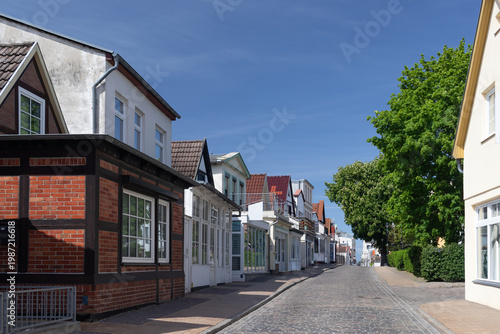 Quiet street with traditional brick and rendered buildings in the historic center of Warnemünde seaside resort, Rostock, Germany