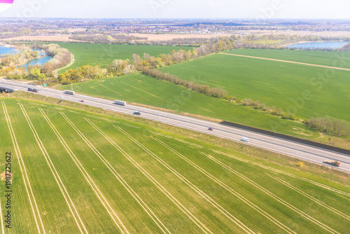 Aerial view of highway cutting through rural farmland landscape