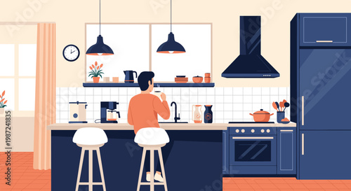 Man drinking coffee while sitting at a kitchen counter in a modern interior with blue cabinets and a large window in the background.