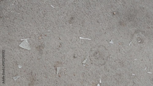 Shattered glass pieces scattered on a gray surface, showing gradual increase in visible fragments across three sequential frames of the same scene