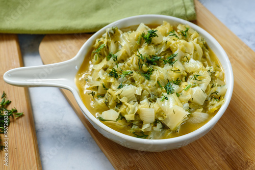Stewed young cabbage with butter and dill