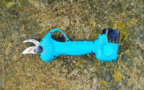 used professional electric cordless pruning shear, a modern agricultural tool designed to make branch cutting more efficient