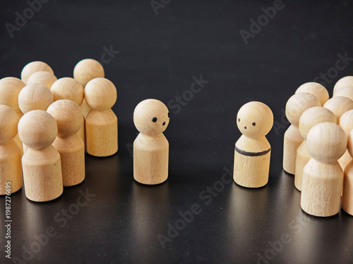 Wooden figures represent choices of individuals standing alone against group pressure in a simple setting