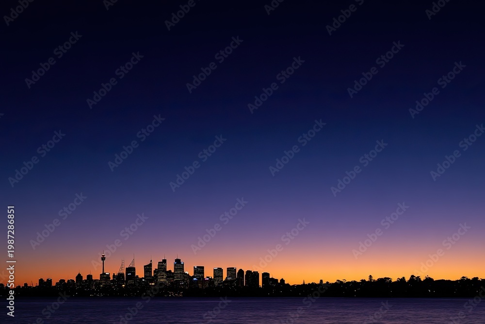 Naklejka premium City skyline silhouetted against a twilight gradient sky over water