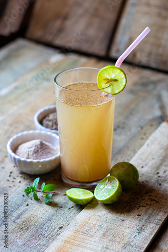Jal Jeera Indian Summer Drink with Lime Slice Mint and Spices in Glass on Rustic Wooden Background