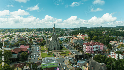 Fotografía Vista aérea da Catedral de Pedra no centro de Canela, Rio Grande do Sul, destacando a arquitetura neogótica, o entorno urbano e a paisagem da Serra Gaúcha em dia ensolarado
