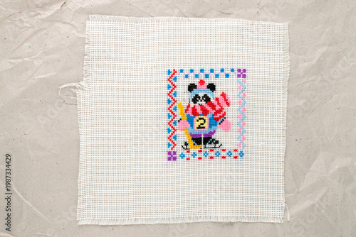 Fotografie Cross-stitch embroidery on light fabric, macro, top view.