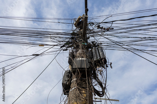Electric pole with tangled cables urban infrastructure background