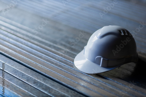 White safety helmet on metal surface construction concept