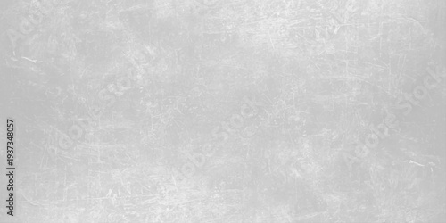 A dark grey brushed metal texture with a grunge pattern on an old rough surface creates a vintage aged backdrop for a textured industrial design. Light gray concrete wall texture background