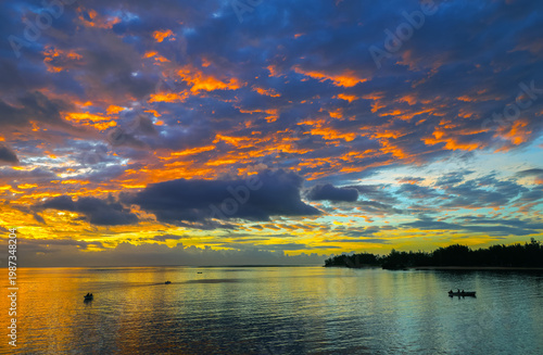 Scenic tropical sunset over the Indian Ocean, Baie du Cap, Mauritius, Africa. Fishing boat on the ocean, Mauritius.	