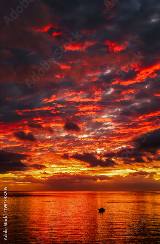 Scenic tropical sunset over the Indian Ocean, Baie du Cap, Mauritius, Africa. Fishing boat on the ocean, Mauritius.	