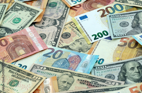 Money banknotes mix of Eurozone Euros and United States Dollars in big pile on table