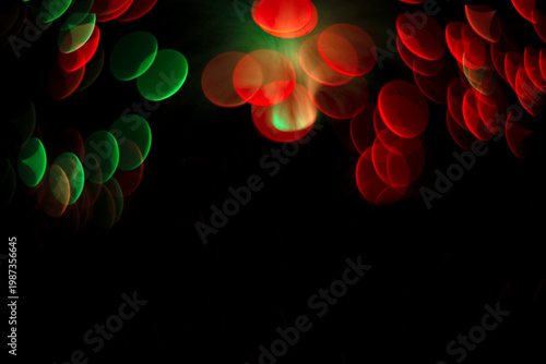 Red and green bokeh lights on dark background festive abstract composition with copy space