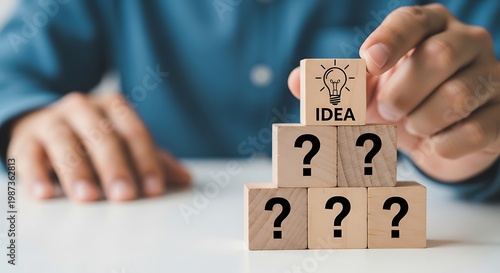 Businessman placing idea block on top of question mark blocks symbolizing innovation