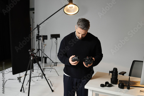 Konstfotografi Creative man assessing camera equipment in a bright photography studio