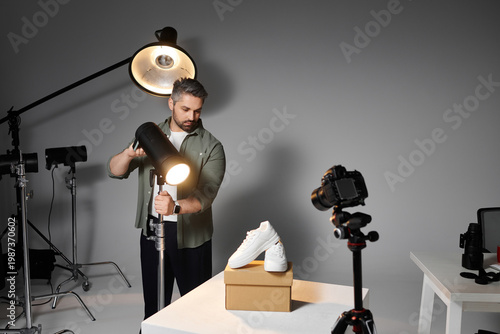 Картината върху платно Professional photographer directing lighting for a product shoot in a creative s