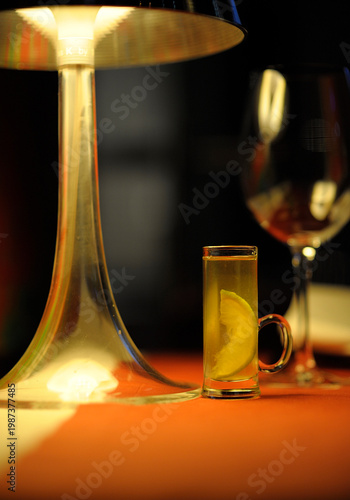Shot of Becherovka herbal liqueur with a lemon slice on a restaurant table