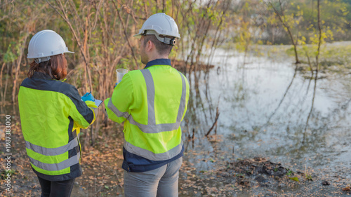 Fotografi Environmental engineers collect water samples from a swamp for quality testing