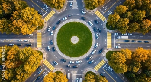 Aerial view of busy traffic roundabout surrounded by autumn trees with yellow foliage showcasing urban transportation and infrastructure