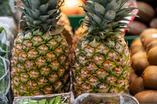 Pineapples and other fruits on display at a market in late afternoon hours