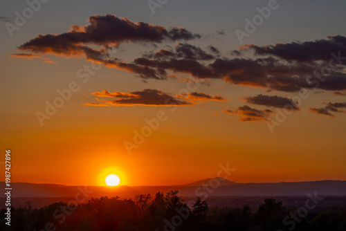 Golden sunsetting over mountain range creating warm atmospheric light