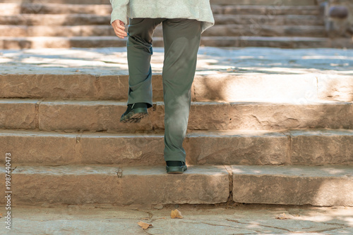 An 85-year-old grandmother and her daughter walk up stone steps in a park