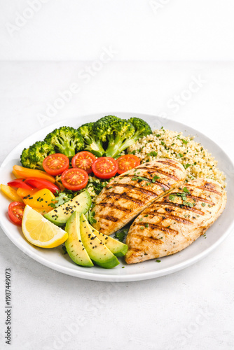 Grilled Chicken Plate: A meticulously arranged plate showcases grilled chicken breasts alongside an array of vibrant, healthy components, emphasizing freshness and nutritional balance.