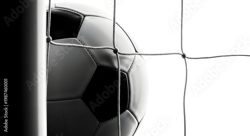 A soccer ball partially in the net, ready for the game