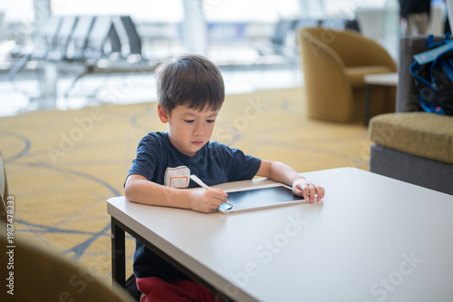 Young Boy Engaged in Creative Drawing at Airport Lounge with Modern Design