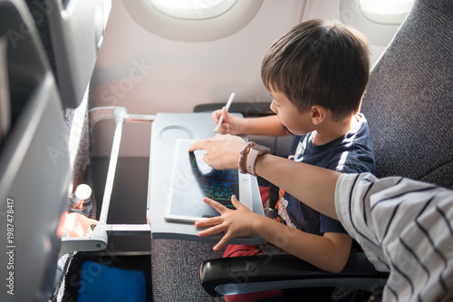 Child Engaged in Creative Drawing on an Airplane with Parent's Guidance