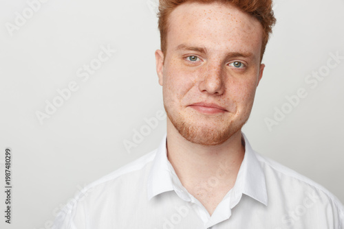 Konstfotografi Redhead man with beard and blue eyes wearing white shirt looks at camera with slight smile