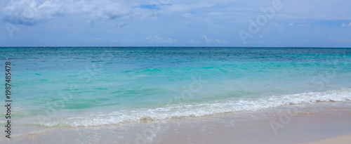 Caribbean Sea beach with white sand and clouds sky.
