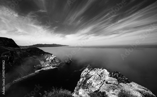 Potato Harbor on Santa Cruz Island with mist coming in under blue cirrus sky in the Channel Islands National Park offshore from Santa Barbara California USA - black and white