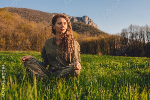 Woman Sitting in Meadow Enjoying Sunlight in Early Spring