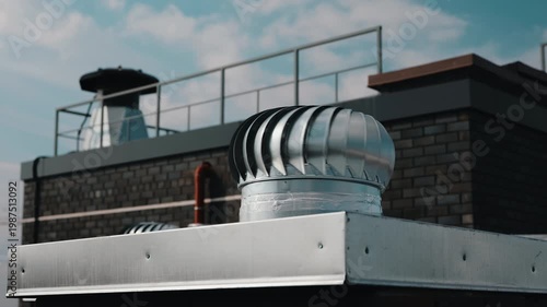 Rooftop ventilation unit against sky and brick wall background