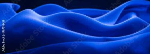 Fabric displays deep blue silky texture with elegant folds that create a soft flowing surface on a dark background, offering generous copy space for various creative projects.