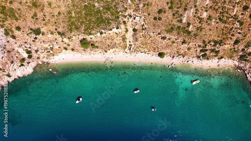 Aerial top down view of Nugal Beach near Makarska, Croatia, with crystal clear turquoise water of the Adriatic Sea and boats anchored near the rocky coastline