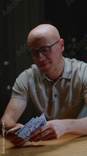 Close up: man trader or businessman counts salary usd banknotes at home with his hands. Male entrepreneur holds stack of dollar bills in palms, keeps money records for budget. Counting american paper