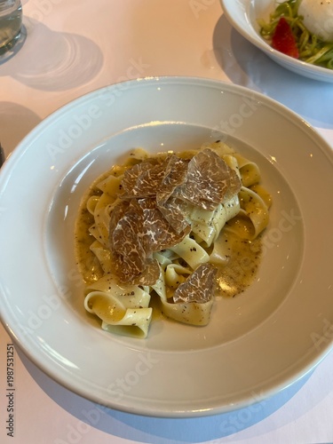 Luxury tagliatelle pasta topped with fresh truffle shavings.

A high-end restaurant dish featuring tagliatelle pasta tossed in butter sauce and finished with thin slices of black or white
