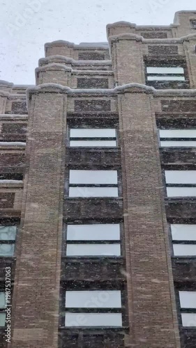 Snow falling over New York city streets with historic architecture, winter atmosphere, cold weather, seasonal snowfall, atmospheric cityscape