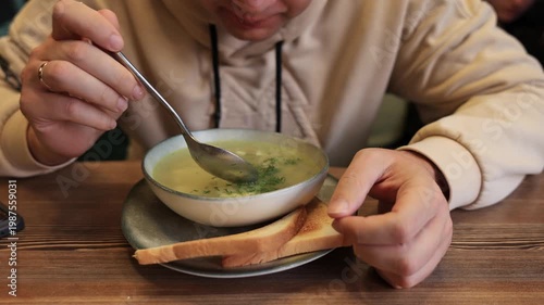 Close-up of a man eating noodle soup in a restaurant. Slow motion video.