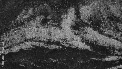 Abstract black-and-white texture of rough, layered surfaces. Dark and light tones create a gritty, tactile feel. Ideal for backgrounds, design elements