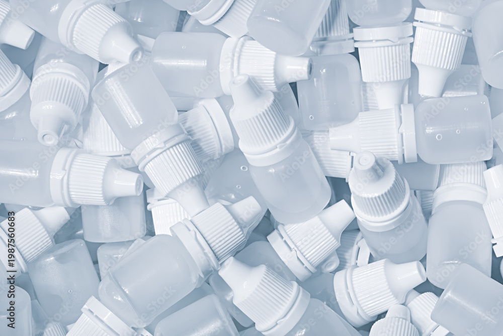 Obraz premium White plastic medical bottles vials for medicinal nose or eye drops as a solid white textured background, medical health concept