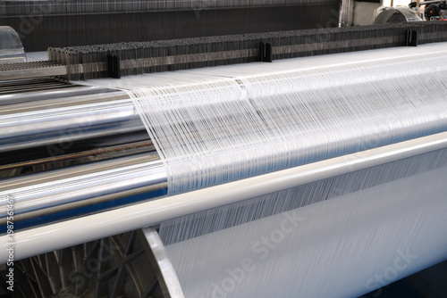 Cuadro en lienzo Large textile loom weaves white fabric with precision